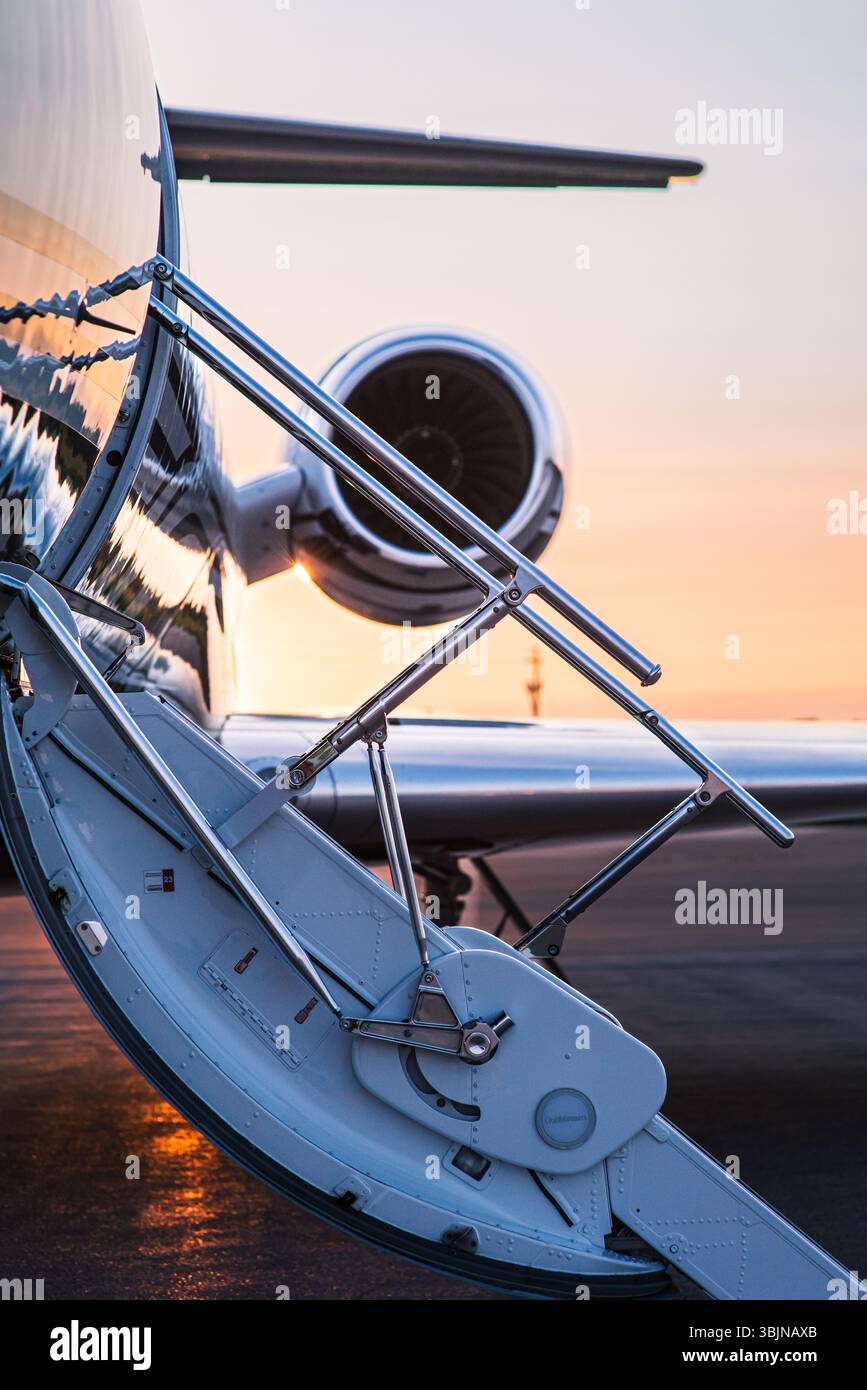 Détail des escaliers de jet privé, ouvert et prêt pour l'embarquement. Reflétant une lueur dorée de coucher de soleil. Détails de voyage de luxe. Banque D'Images