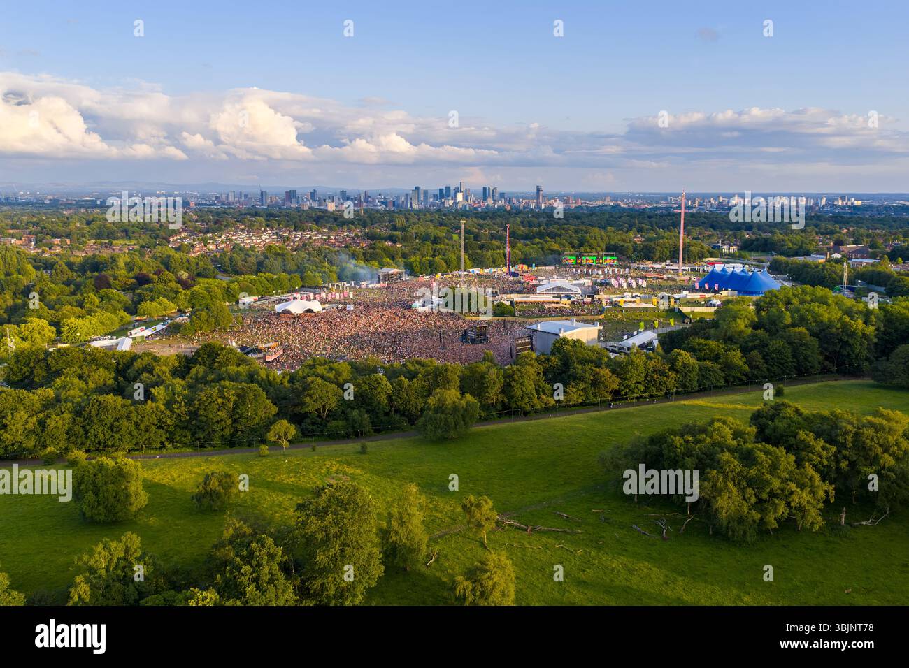 Image aérienne de Heaton Park dans le Grand Manchester avec Parklife Outdoor Music Festival avec Manchester City skyline en arrière-plan. Banque D'Images