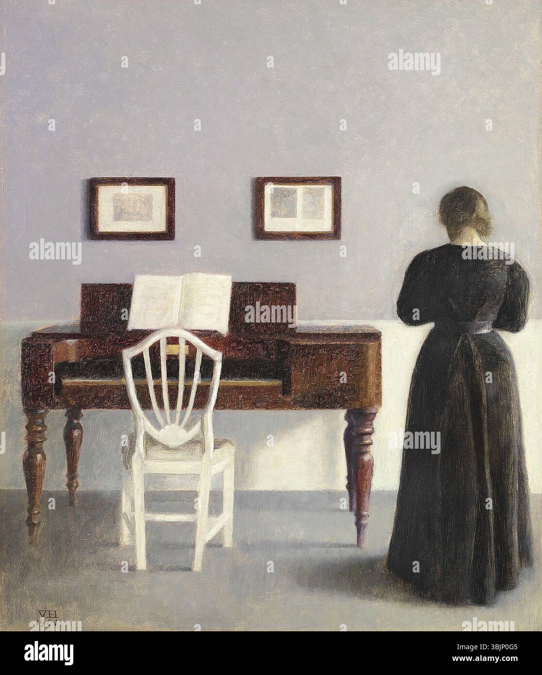 La peinture à l’huile de Vilhelm Hammershøi de 1901, « intérieur avec la femme de l’artiste vue de derrière », représente la femme de l’artiste dans leur appartement à Strandgade 30. Connue pour son approche minimaliste, cette peinture exclut les panneaux muraux et met en valeur la couleur et les deux petites images. Banque D'Images