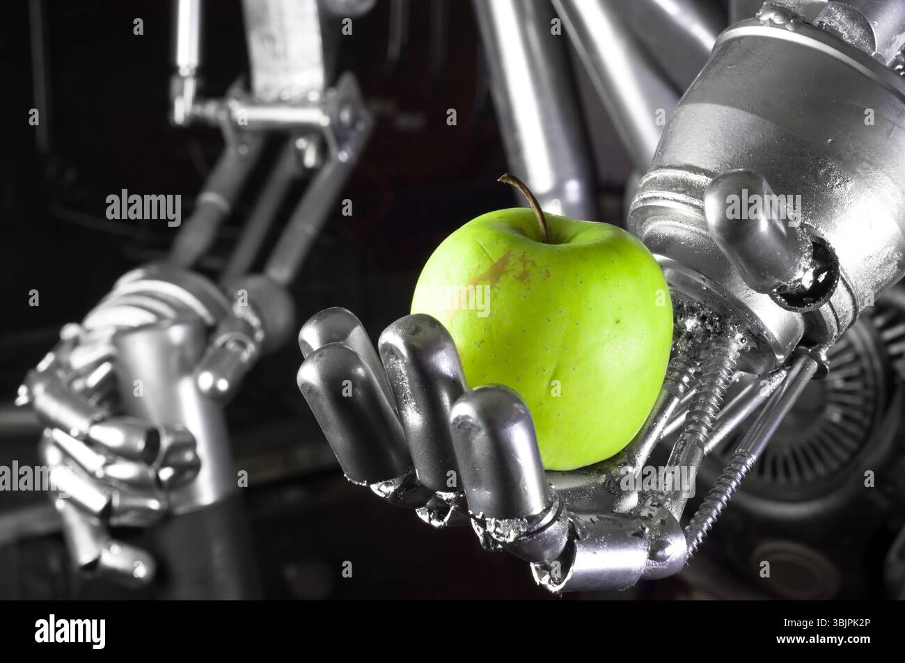 Main robot tenant la pomme verte Banque D'Images