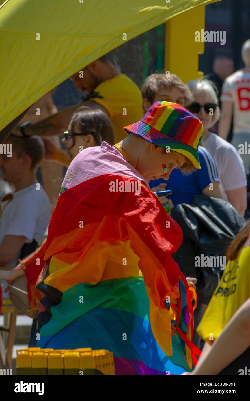 Enfant drapé dans des marches de drapeau arc-en-ciel à Varsovie Pride Parade à Varsovie, Voïvodie de Masovian, Pologne. Juin 2025. Banque D'Images