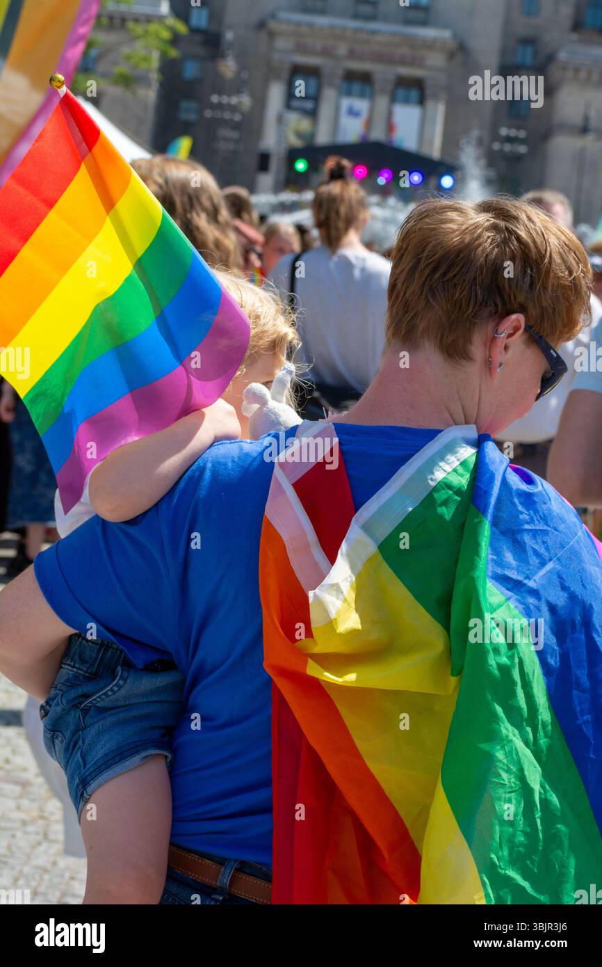 Parent drapé dans le drapeau arc-en-ciel porte l'enfant avec le drapeau de la fierté à Varsovie Pride Parade à Varsovie, Voïvodie de Masovian, Pologne juin 2025 Banque D'Images