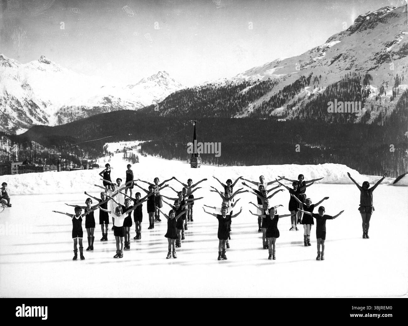 Enfants faisant des exercices matinaux dans la neige vers 1940, enfants pratiquant dans un groupe chorégraphié dans un paysage montagneux enneigé, photo historique Banque D'Images