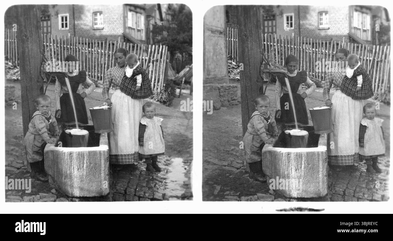 Femmes allant chercher de l'eau, années 1920, femmes et enfants à la pompe à eau dans la cour, montrant la scène quotidienne, noir et blanc, photo historique Banque D'Images
