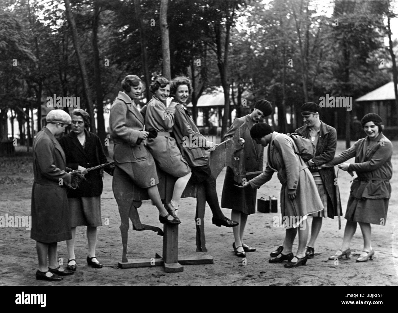 Groupe de femme, années 1920, Un groupe de femme dans un parc profitant du temps sur une balançoire, photo historique Banque D'Images