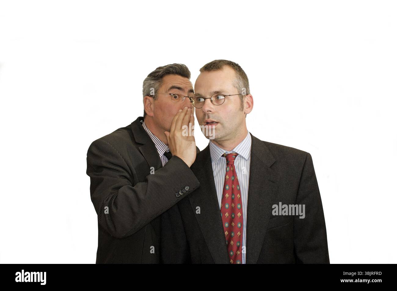 Homme d'affaires, deux, chuchotant, communication, costume et cravate, Berlin, Allemagne, homme en costume chuchotant à l'oreille d'un autre homme, ils semblent partager un secret, Banque D'Images