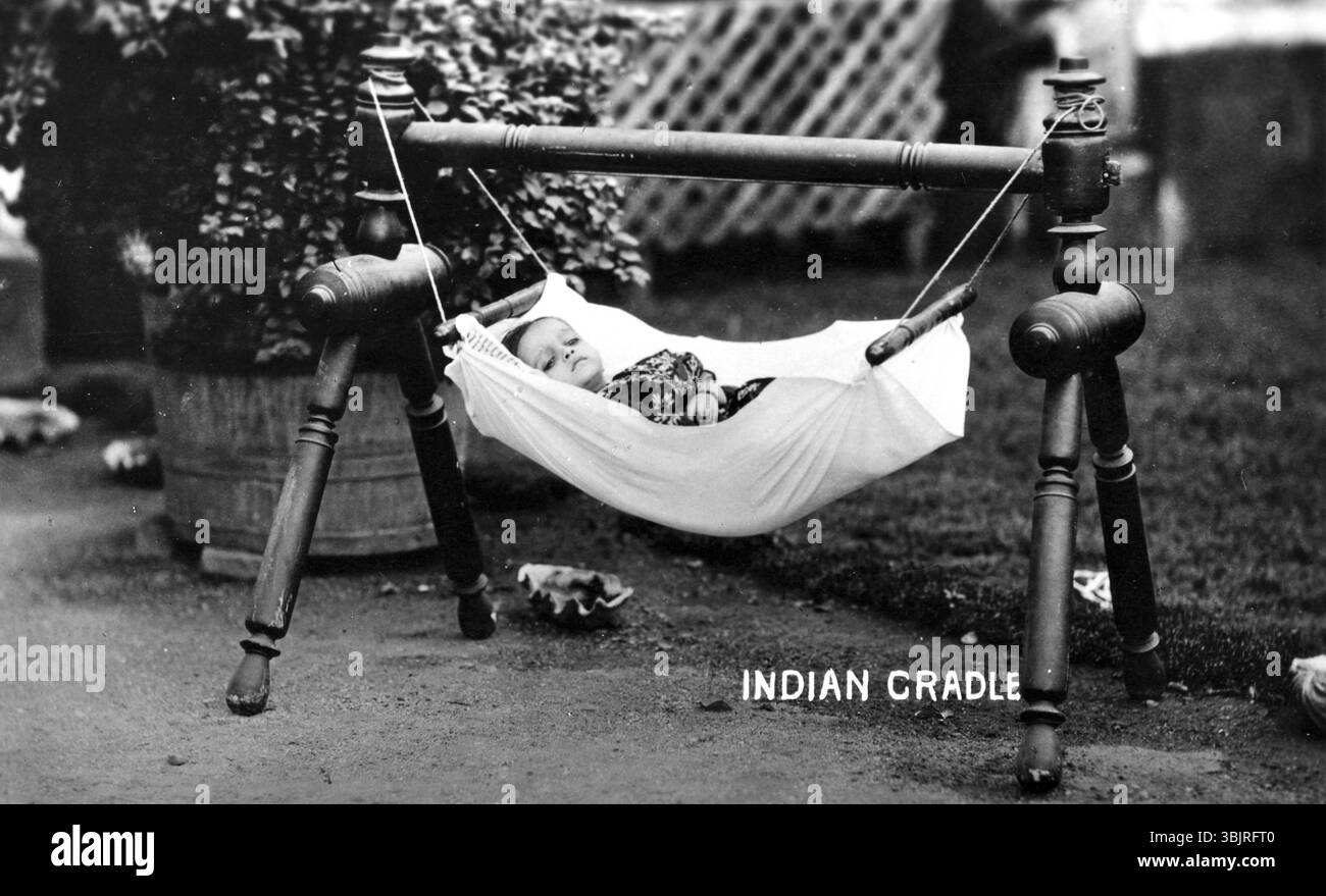 Berceau hamac bébé, années 1930, Un bébé se trouve dans un berceau suspendu dans le jardin, entouré de plantes, photo historique Banque D'Images