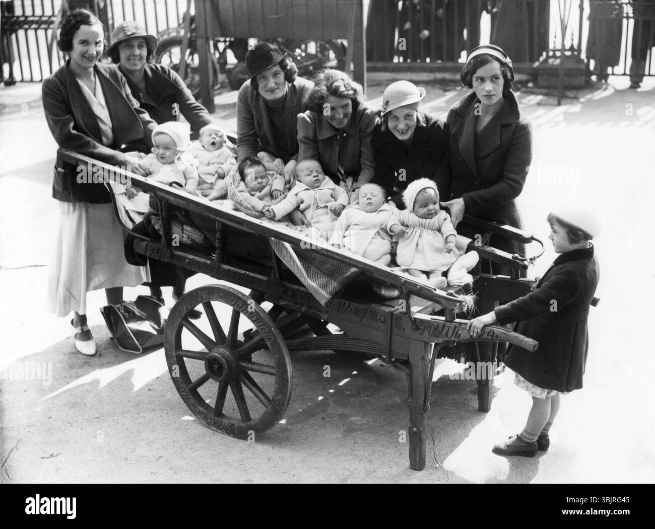Chargement de bébés, années 1920, femme avec des bébés dans des chariots debout dans une rue, photo historique Banque D'Images