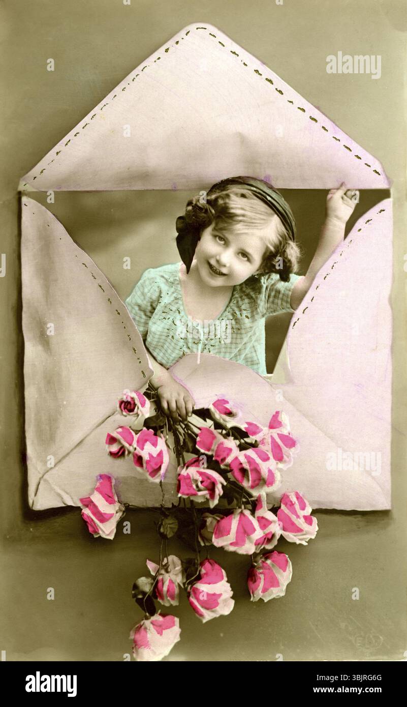 Enfant dans une enveloppe, 1910, fille regardant à travers une enveloppe en forme de coeur et tenant des fleurs, photo historique Banque D'Images