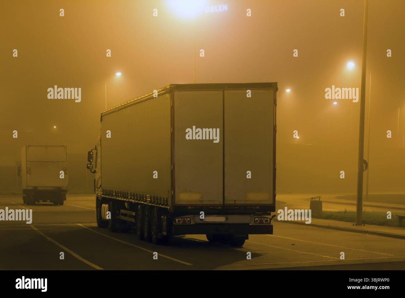 Transport de marchandises par route, industrie du camionnage - camion semi-remorque, véhicule en surpoids, grand véhicule de marchandises dans le stationnement, dans le brouillard de nuit, route brumeuse Banque D'Images Transport de marchandises par route, industrie du camionnage - camion semi-remorque, véhicule en surpoids, grand véhicule de marchandises dans le stationnement, dans le brouillard de nuit, route brumeuse Banque D'Images