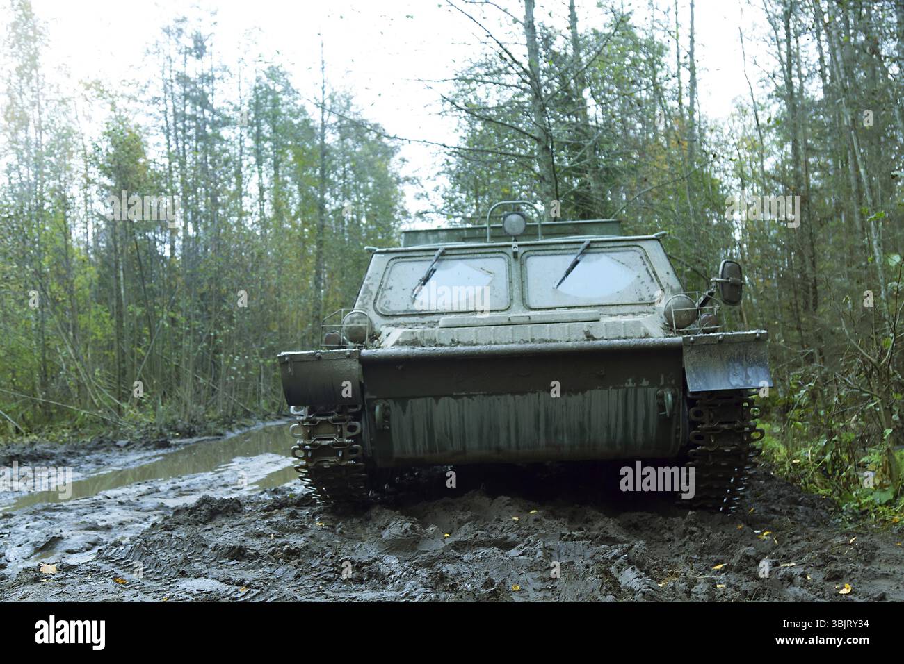 Véhicule tout-terrain de la taïga soviétique et de la toundra sur piste, le truk caterpillar (véhicule à chenilles, à transport, à marécages de neige) se trouve sur une route boueuse de la taïga Banque D'Images Véhicule tout-terrain de la taïga soviétique et de la toundra sur piste, le truk caterpillar (véhicule à chenilles, à transport, à marécages de neige) se trouve sur une route boueuse de la taïga Banque D'Images