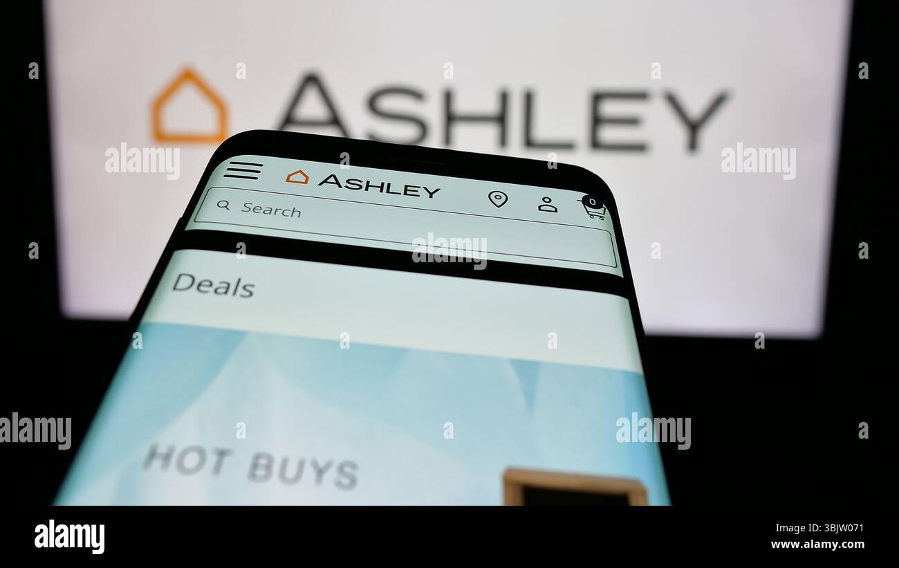 Stuttgart, Allemagne - 2025 : téléphone portable avec la page web de la société américaine Ashley Furniture Industries Inc. sur l'écran devant le logo. Banque D'Images
