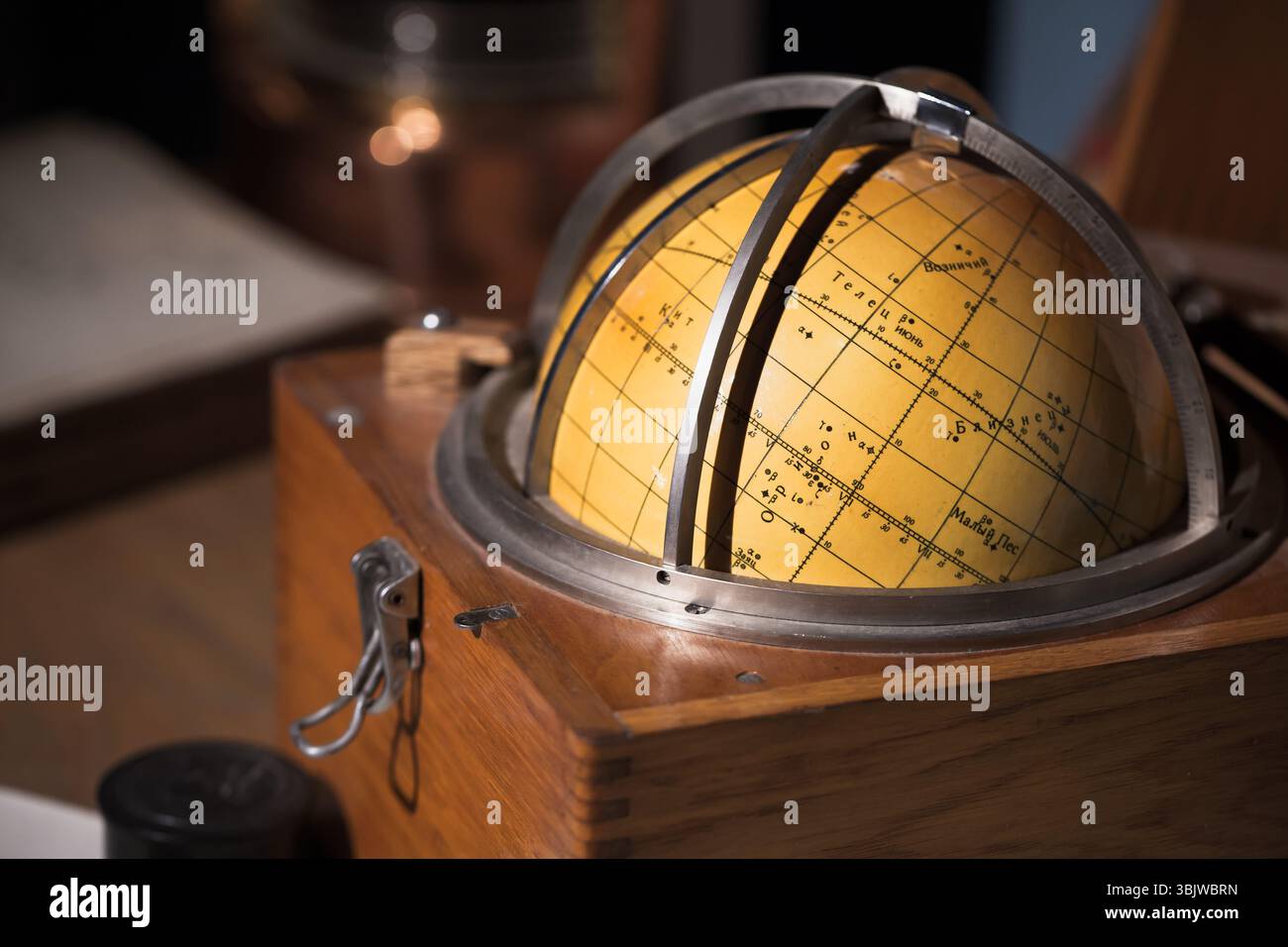 Globe céleste vintage posé sur un bureau en bois, évoquant les thèmes de l'exploration et de l'astronomie. Le texte russe signifie : Gémeaux, Verseau, Canis Major Banque D'Images