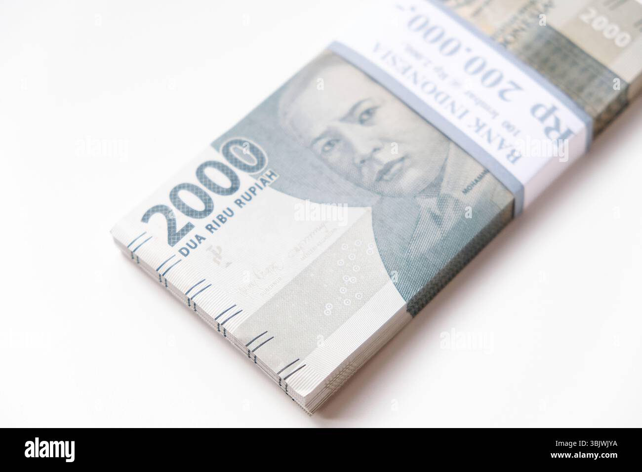 Pekanbaru, Indonésie - 21 mars 2025 : une pile de billets de banque rupiah indonésiens RP 2,000 isolés sur fond blanc pour THR sur Eid al-Fitr ou Lebaran Banque D'Images