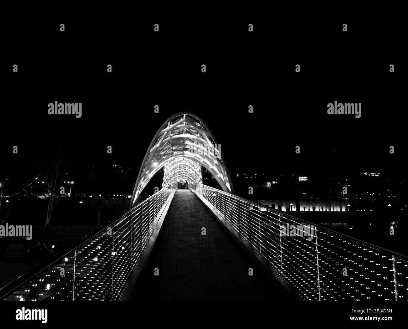 Pont de la paix sur la rivière Kura avec illuminé la nuit. Tbilissi, Géorgie. Banque D'Images