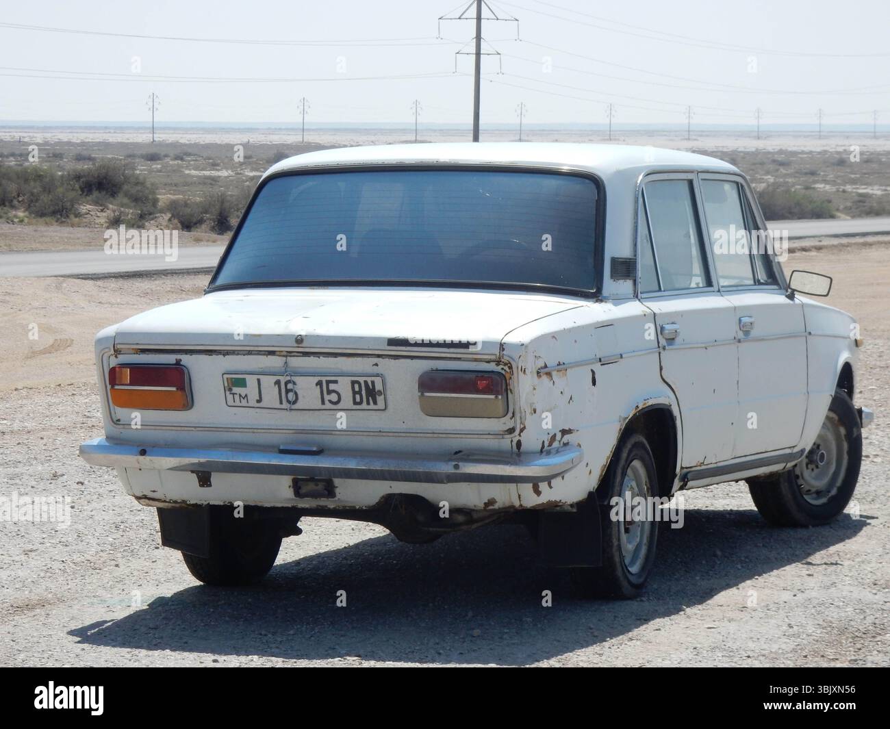 Une voiture Lada de style soviétique sur une route au Turkménistan Banque D'Images