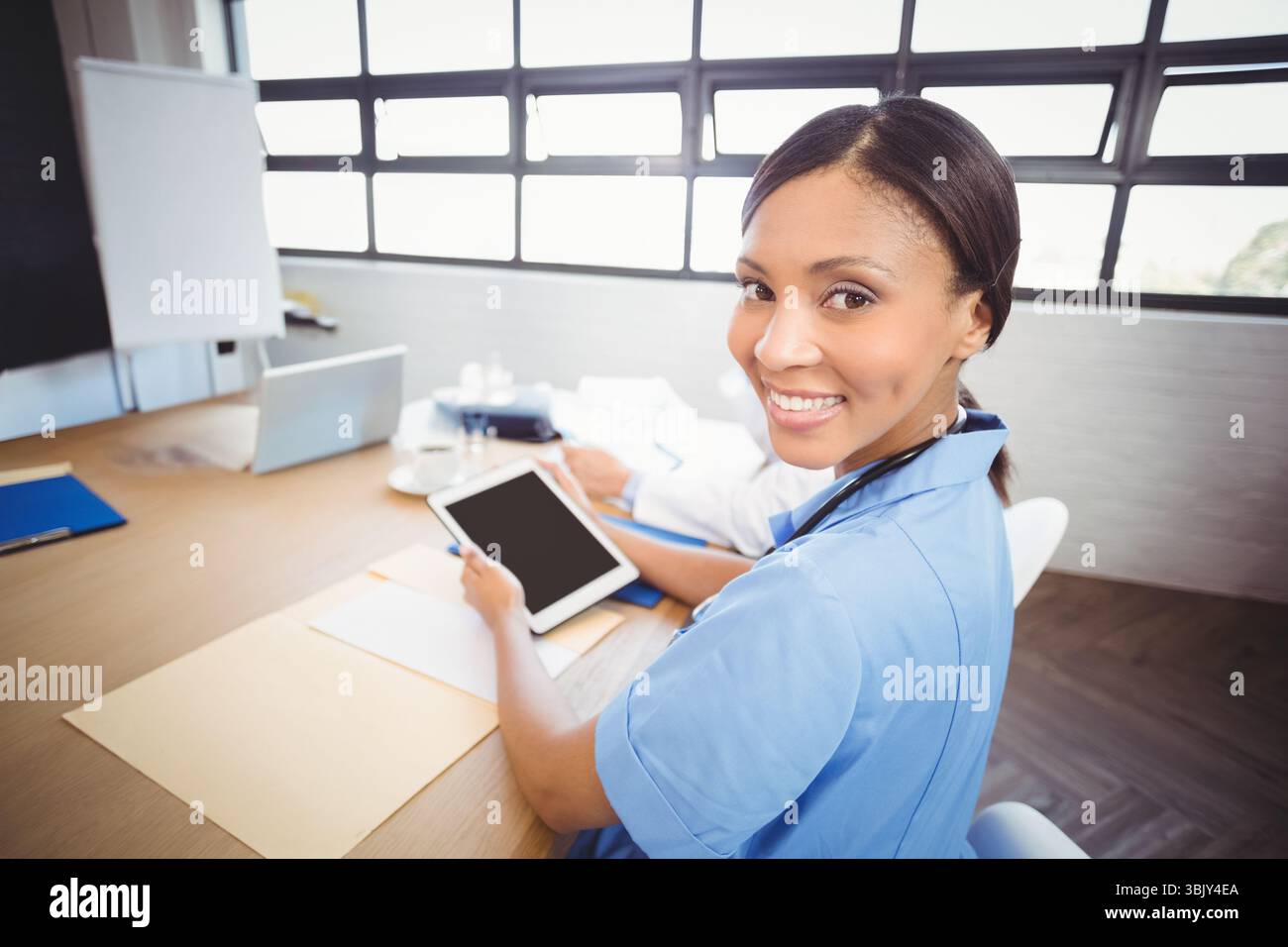 Tablette et ordinateur portable assis à côté de la tasse à café sur la table de conférence en bois dans la salle de consultation Banque D'Images
