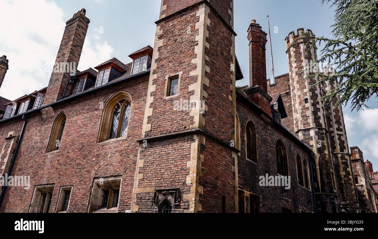 Impressionnante architecture en briques du Collège John's de Cambridge, présentant des cheminées imposantes et des détails ornés sous un ciel nuageux Banque D'Images