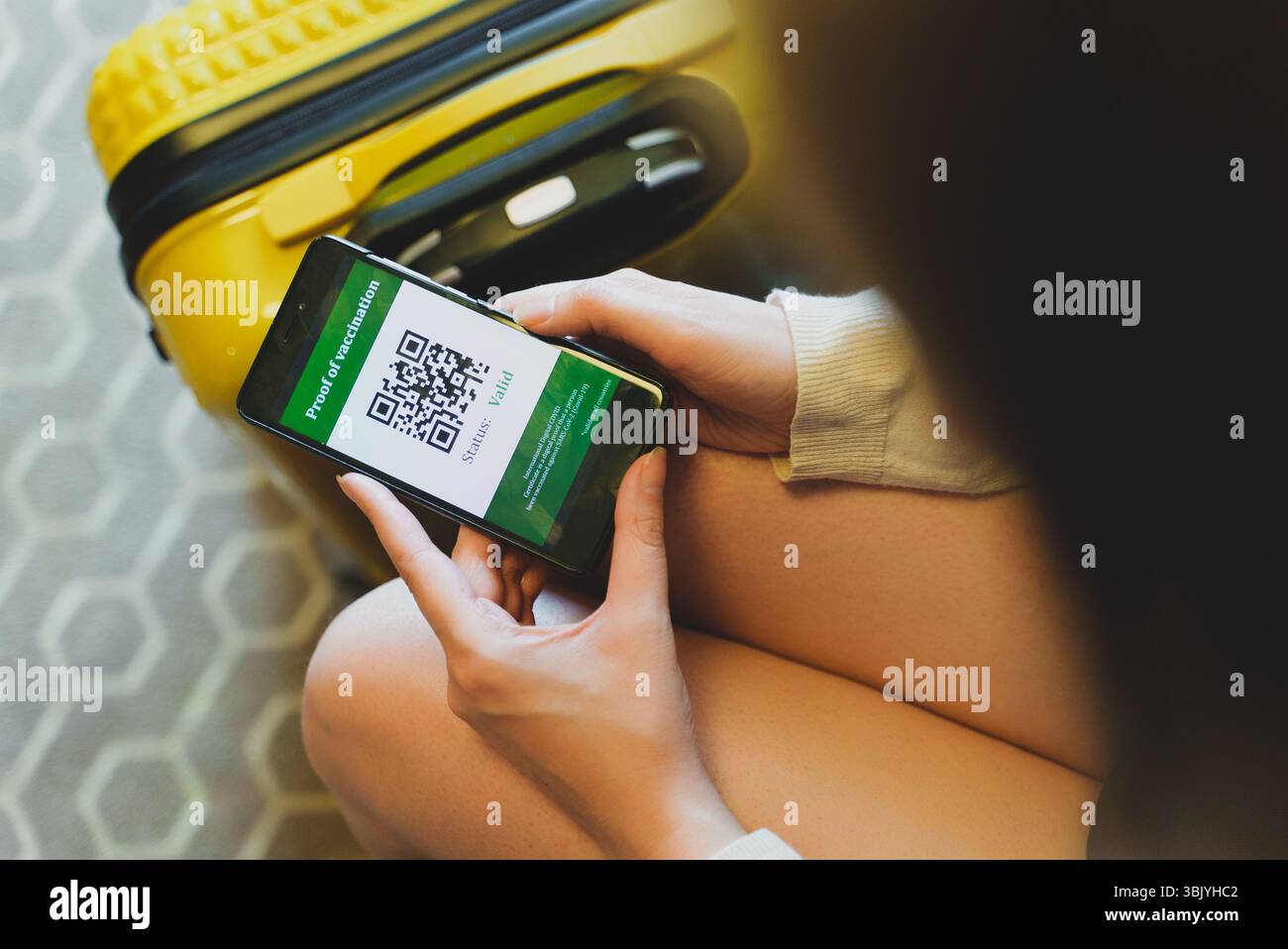 Femme à l'aéroport vérifiant l'application de certification du vaccin contre le coronavirus. L'état est valide. Banque D'Images Femme à l'aéroport vérifiant l'application de certification du vaccin contre le coronavirus. L'état est valide. Banque D'Images