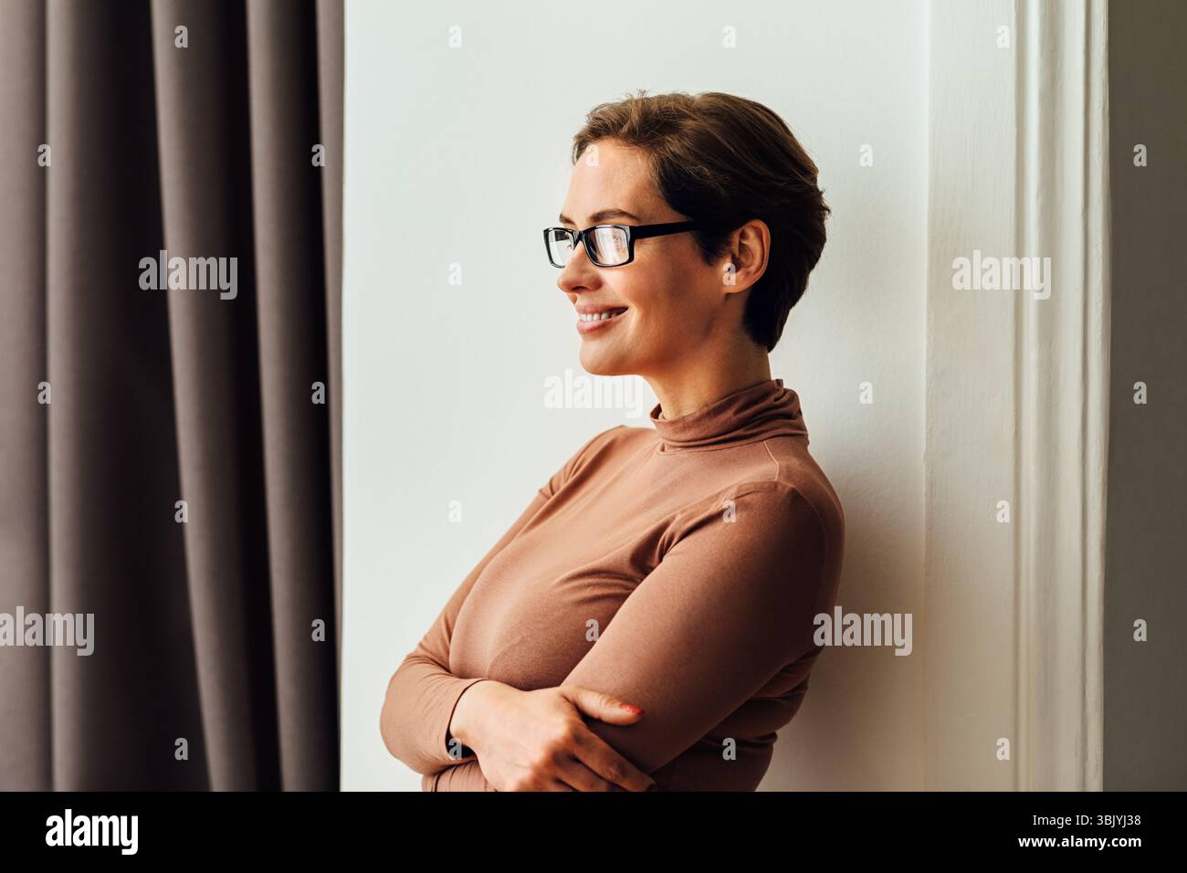 Vue latérale d'une belle femme d'affaires en lunettes debout chambre d'hôtel et vue sur la fenêtre Banque D'Images Vue latérale d'une belle femme d'affaires en lunettes debout chambre d'hôtel et vue sur la fenêtre Banque D'Images