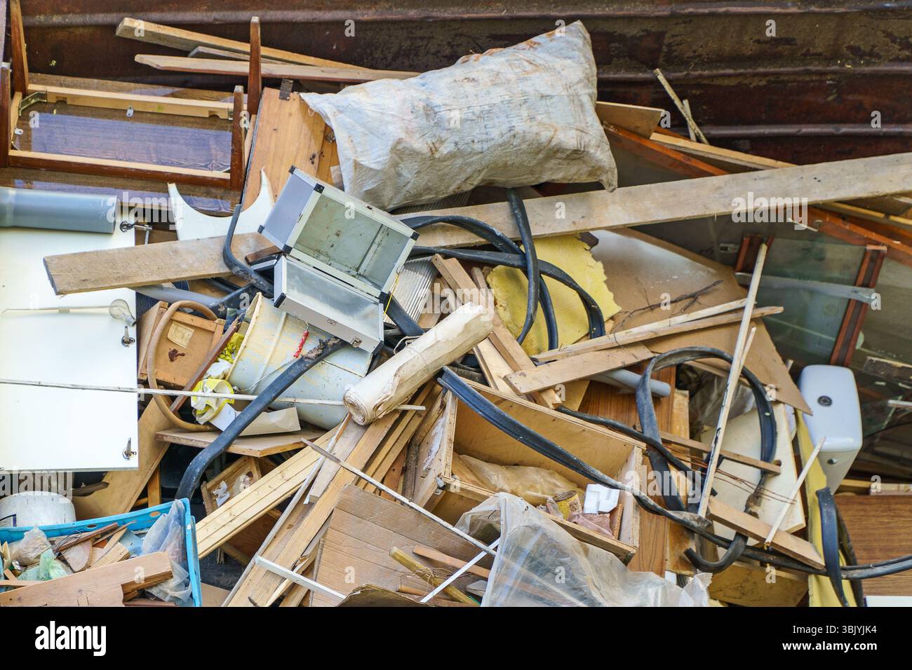 Beaucoup de vieux appareils ménagers et de meubles dans un conteneur à ordures. Banque D'Images