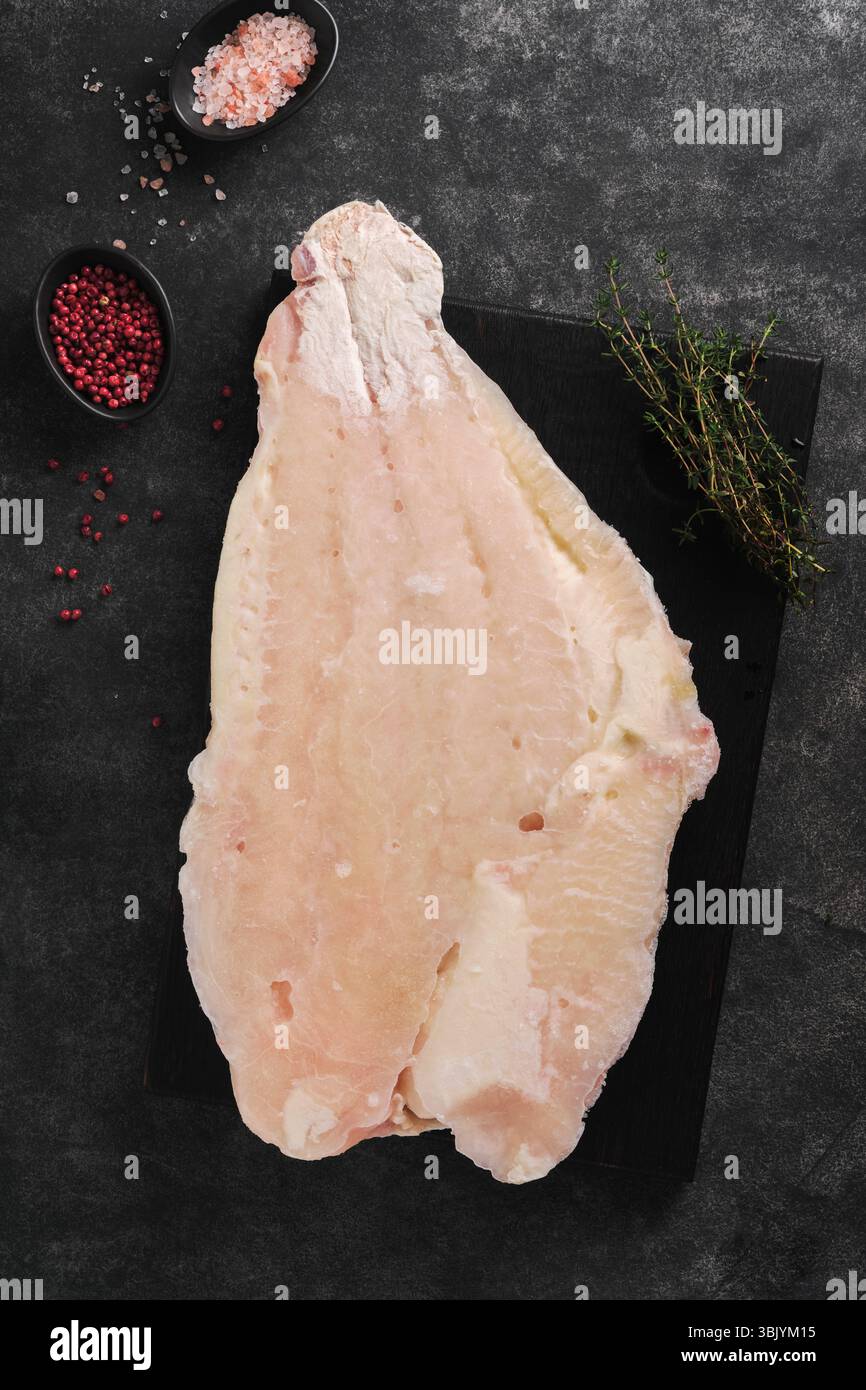Congé congelé Pangasius. Filet cru de poisson-chat blanc. Pangasius aux épices. Arrière-plan noir. Vue de dessus. Banque D'Images Congé congelé Pangasius. Filet cru de poisson-chat blanc. Pangasius aux épices. Arrière-plan noir. Vue de dessus. Banque D'Images