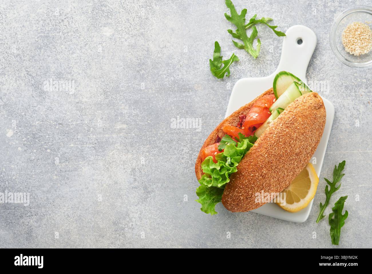 Sandwichs au saumon salé. Ouvrez les sandwichs à partir de pain de céréales ou de seigle à grains entiers avec saumon salé, graines de sésame et t séché Banque D'Images Sandwichs au saumon salé. Ouvrez les sandwichs à partir de pain de céréales ou de seigle à grains entiers avec saumon salé, graines de sésame et t séché Banque D'Images