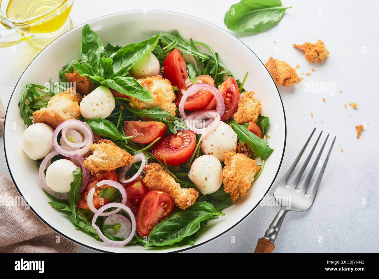 Salade de pain Panzanella. Cuisine traditionnelle de l'Italie avec tomates, boules de mozzarella, basilic, oignon et pain sur backgrou gris clair Banque D'Images Salade de pain Panzanella. Cuisine traditionnelle de l'Italie avec tomates, boules de mozzarella, basilic, oignon et pain sur backgrou gris clair Banque D'Images