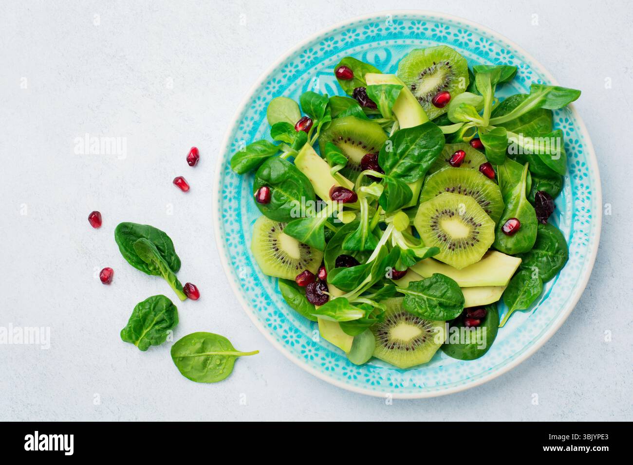 Salade de feuilles de bébé d'épinards, de cresson, de kiwi, d'avocat et de grenade dans une plaque de céramique bleue sur fond de bois clair blanc. Banque D'Images Salade de feuilles de bébé d'épinards, de cresson, de kiwi, d'avocat et de grenade dans une plaque de céramique bleue sur fond de bois clair blanc. Banque D'Images