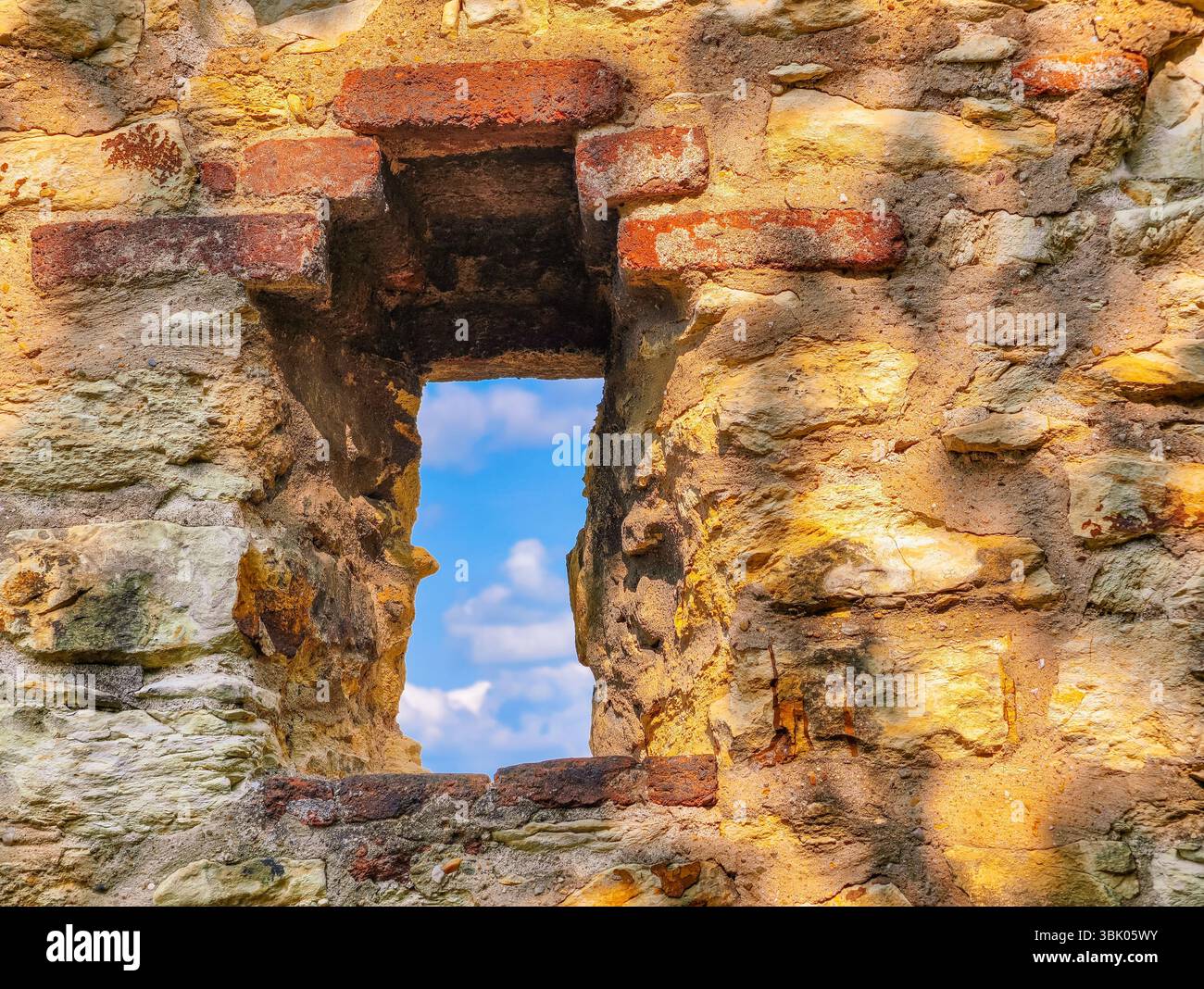 Ancient Battlement Window : un aperçu de l'histoire - mur de pierre captivant avec un design texturé et une vue sur le ciel serein, parfait pour capturer l'essence du patrimoine et de l'architecture historique Banque D'Images