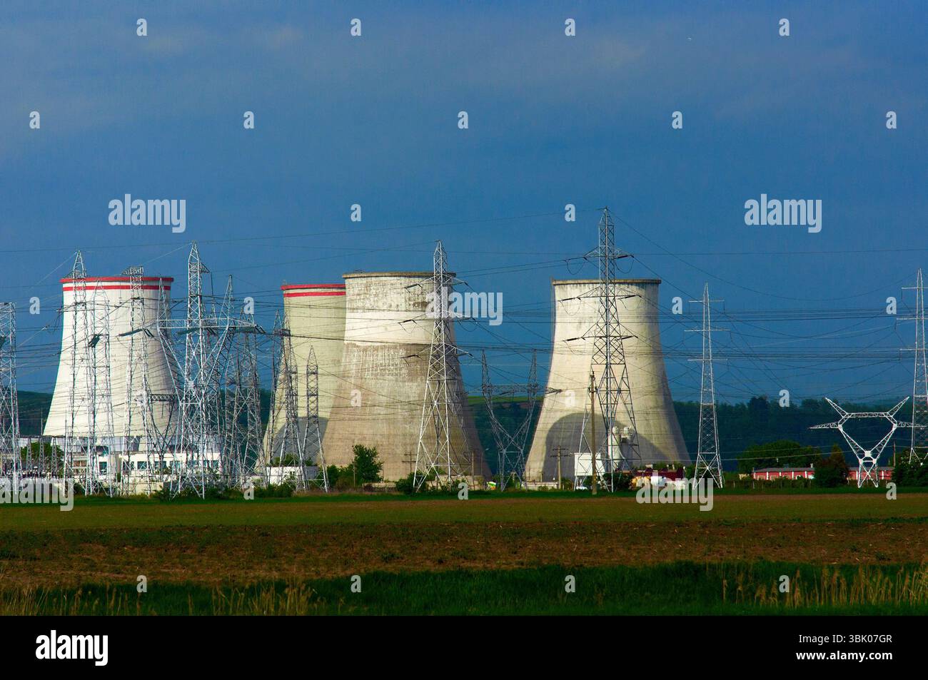 Centrale nucléaire avec pylônes électriques et ciel bleu Banque D'Images