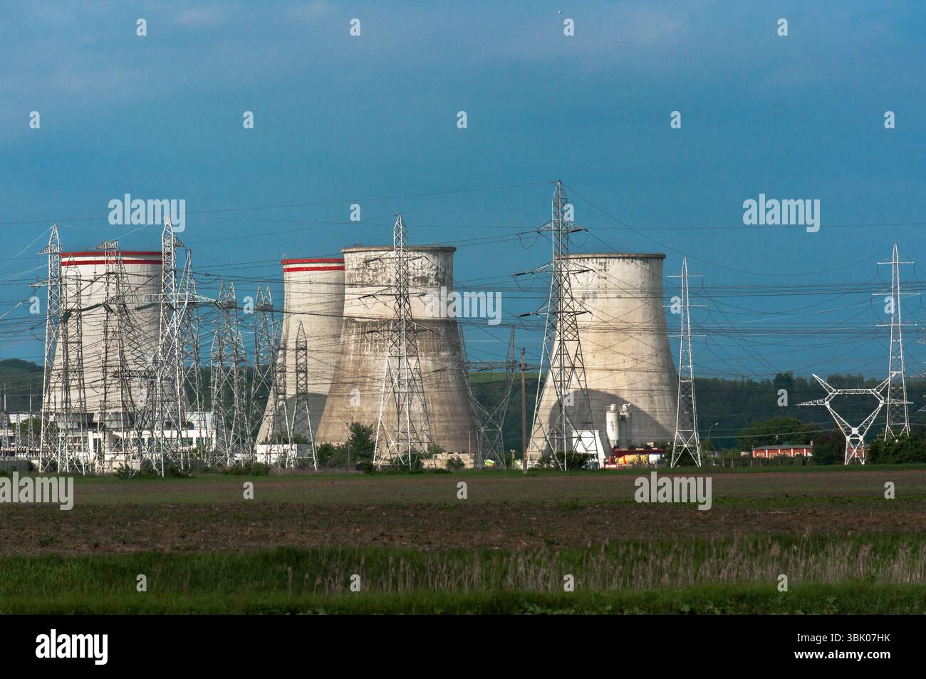 Centrale nucléaire avec pylônes électriques et ciel bleu Banque D'Images