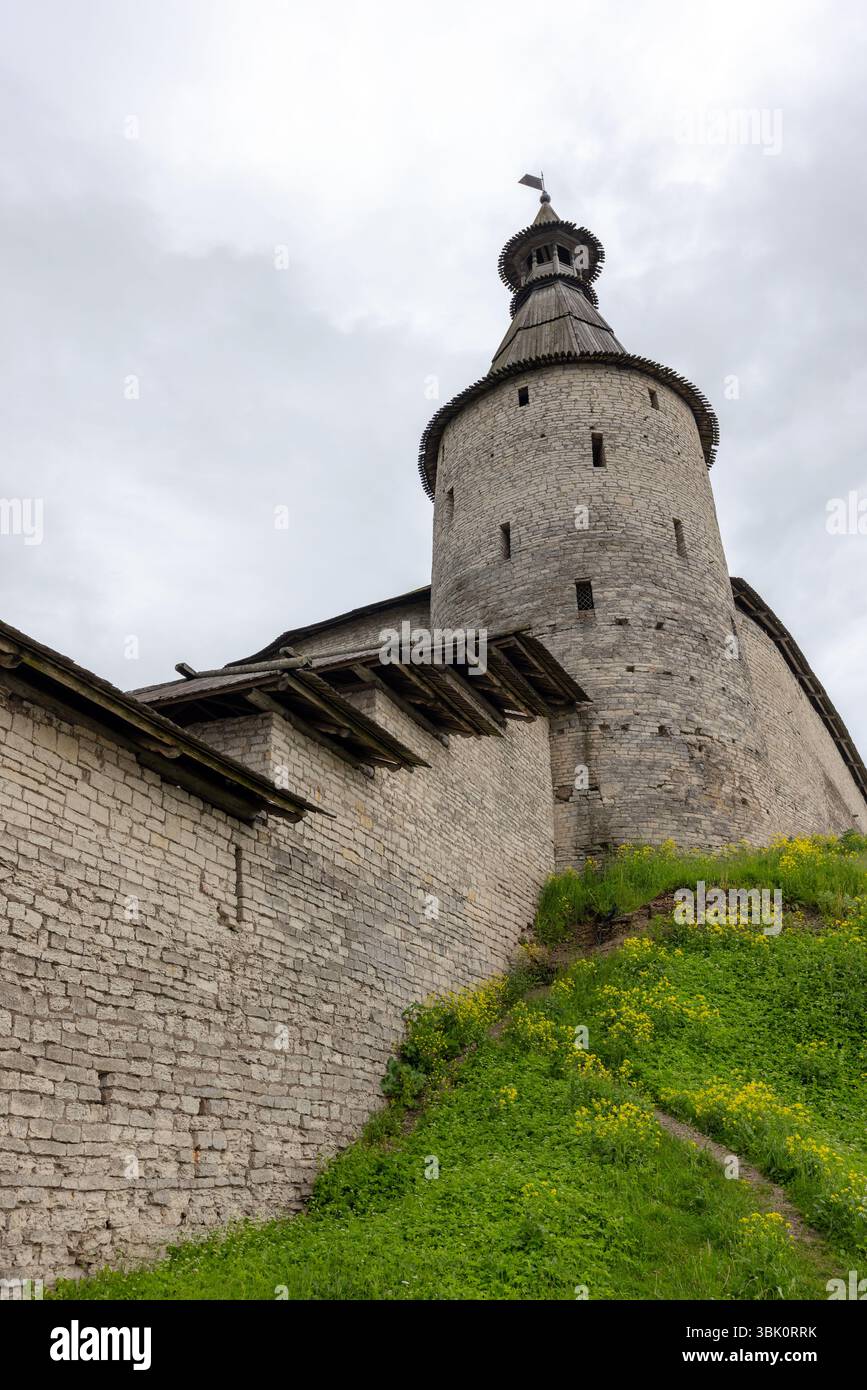 Extérieur Pskov Kremlin. Tour de pierre médiévale se dresse haut contre un ciel nuageux, entouré d'une colline luxuriante herbeuse fleurissant avec des fleurs sauvages, la mise en valeur Banque D'Images
