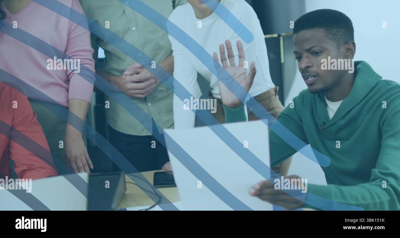 Examen du document, homme noir en sweat à capuche vert assis à la table de bureau avec ordinateur portable, espace de copie Banque D'Images