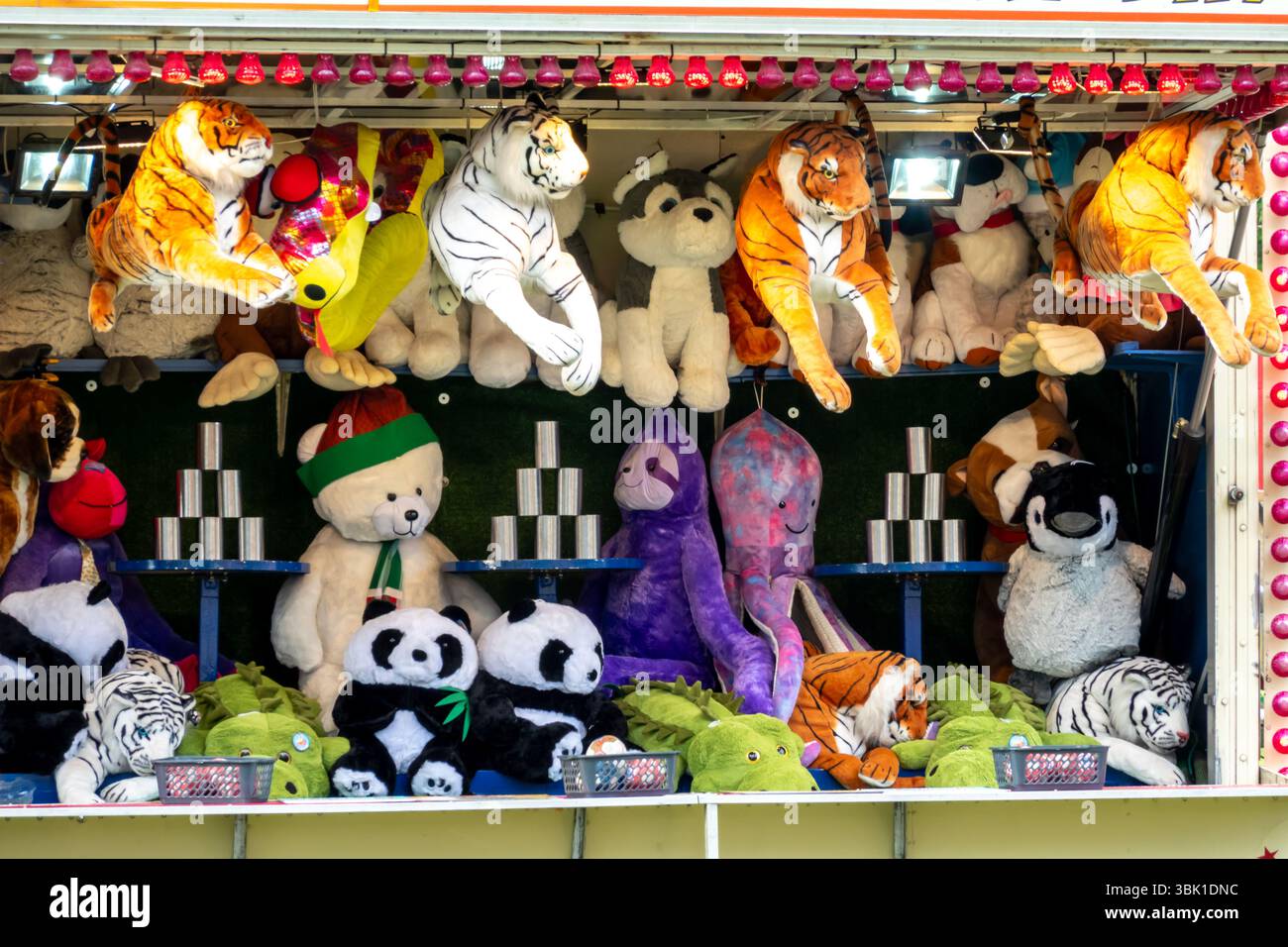 Un stand de jeu de fête foraine dynamique à Saffron Walden, Essex, rempli de prix en peluche, y compris des tigres, des pandas et d'autres jouets. Banque D'Images