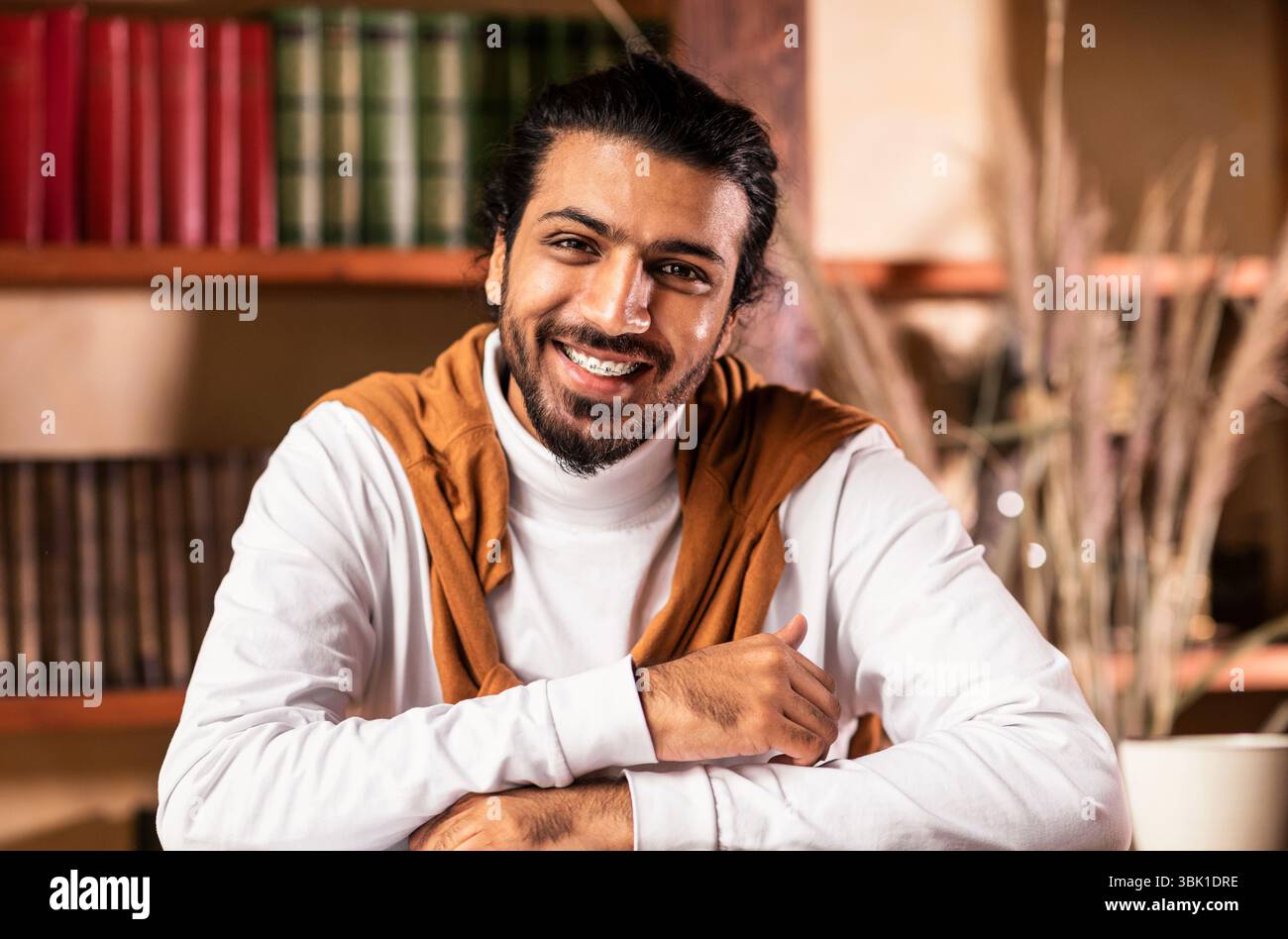 Portrait d'un jeune enseignant arabe assis sur le lieu de travail à l'intérieur Banque D'Images
