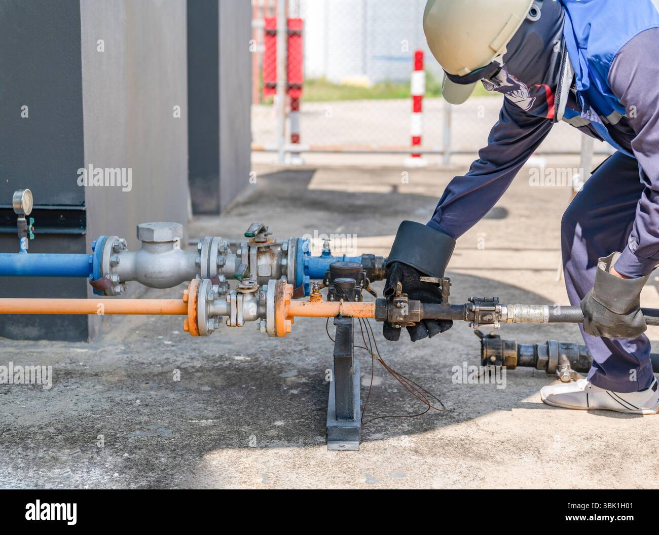 Le technicien connecte le camion de livraison de gaz au réservoir de stockage pour le remplissage dans la station-service. Banque D'Images