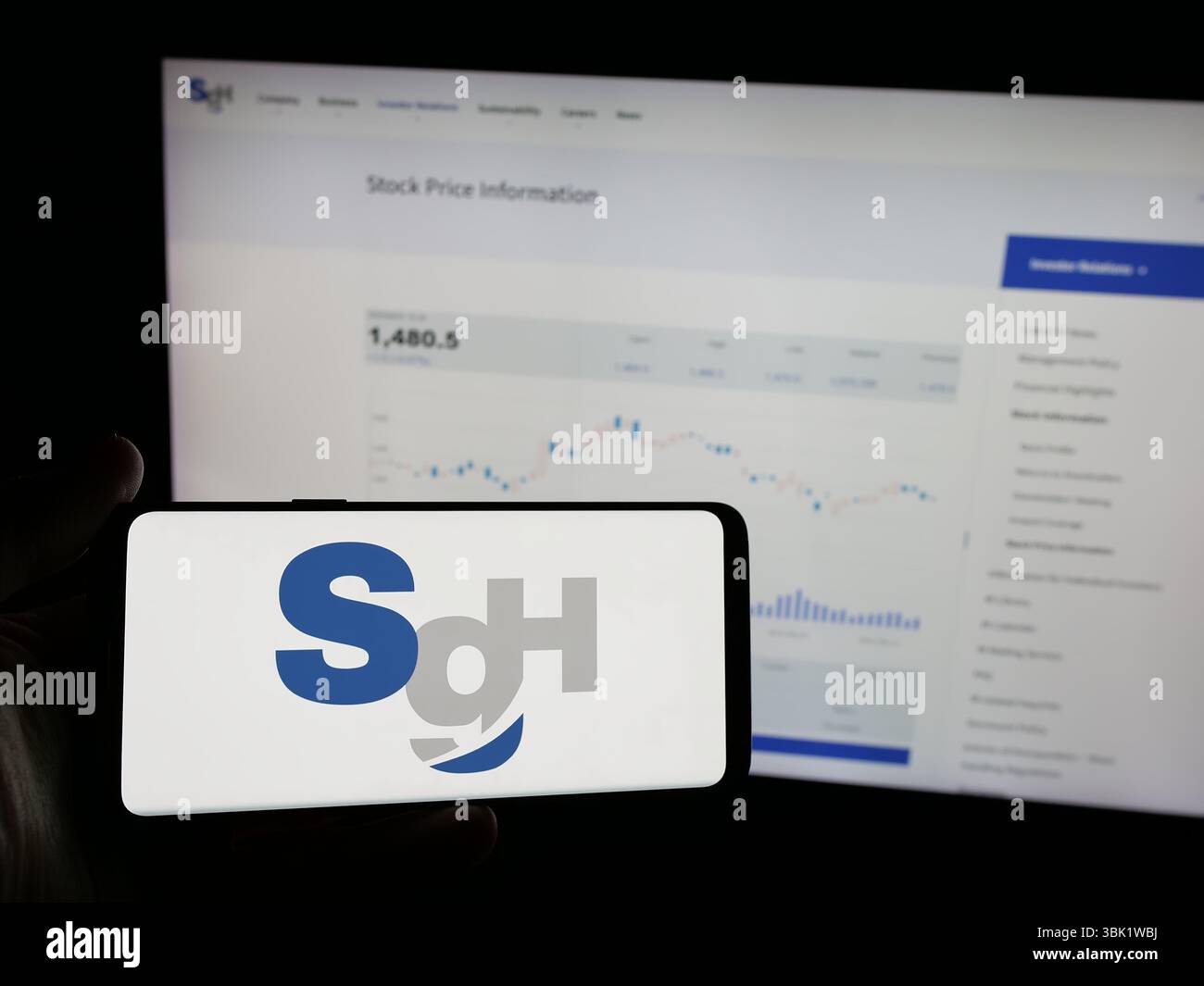 Stuttgart, Allemagne - 04-26-2025, personne tenant un smartphone avec le logo de la société de logistique SG Holdings Co. Ltd sur l'écran devant le site Web. Banque D'Images