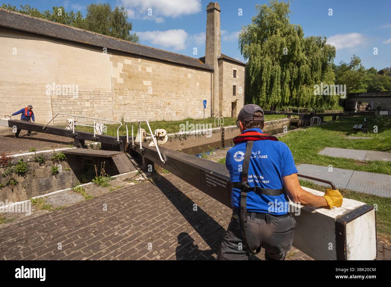 Angleterre, Somerset, Bath, le canal Kennet et Avon, Widcombe Lock et Thimble Mill Lock, Men Opening Lock Gates Banque D'Images
