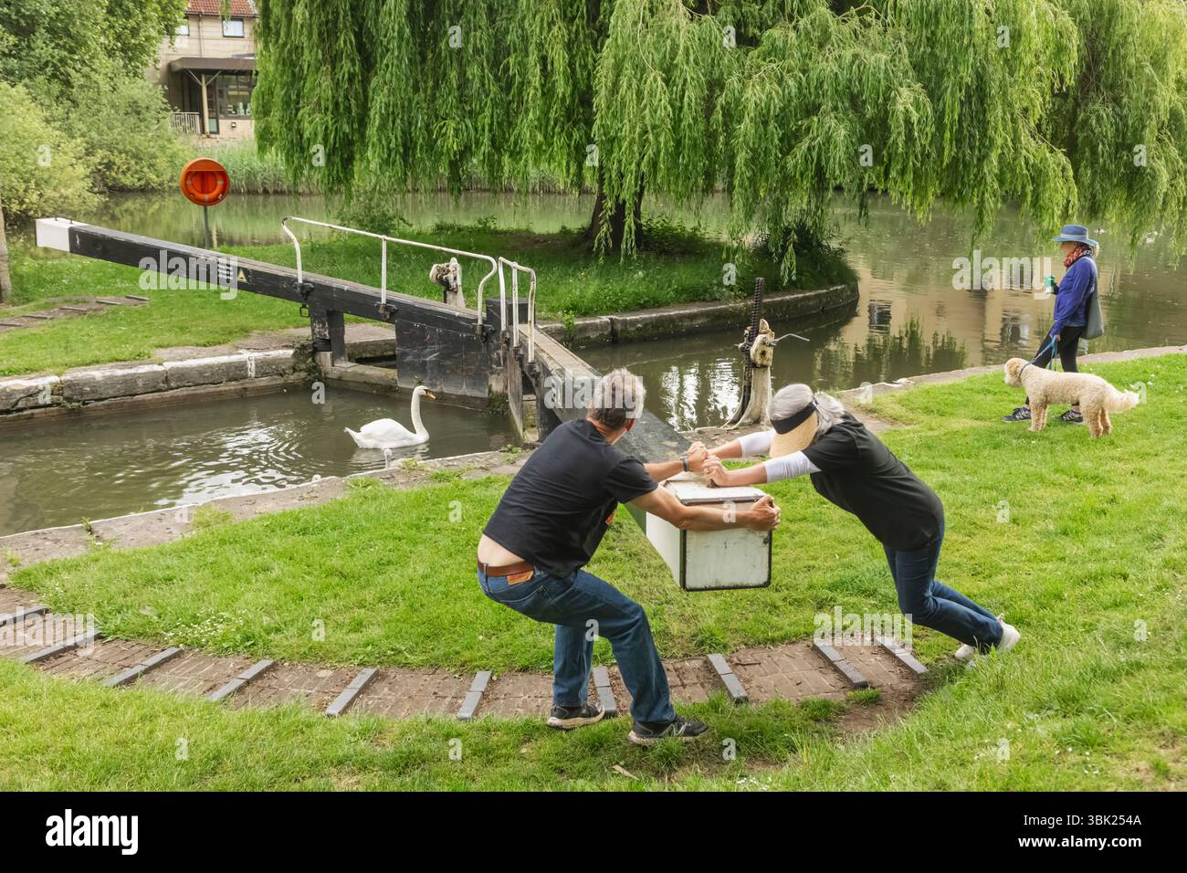 Angleterre, Somerset, Bath, le canal Kennet et Avon, Widcombe Lock et Thimble Mill Lock, couple ouvrant les portes de l'écluse Banque D'Images