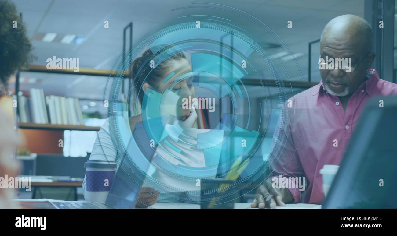 Examen des documents, collègues penchés à la cloison de bureau, avec ordinateur portable, tasses à café et lunettes Banque D'Images