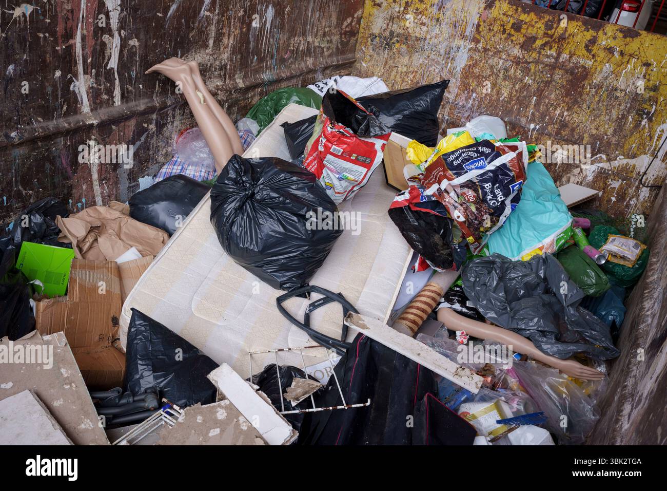 Les jambes et un bras d'un mannequin de vente au détail dépassent d'autres déchets de décharge dans une benne au centre de déchets ménagers et de recyclage de l'arrondissement de Wandsworth sur Smugglers Way, le 17 juin 2025, à Londres, en Angleterre. Les déchets mis en décharge sont l'élimination de déchets qui ne peuvent pas être réutilisés, recyclés ou valorisés, dans ou sur le sol. Banque D'Images