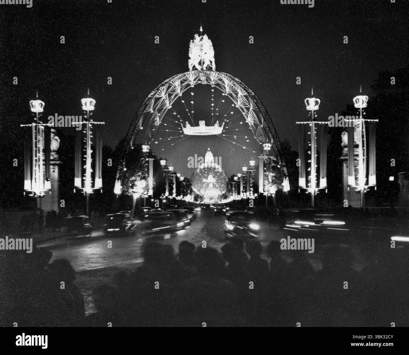 Londres, Angleterre. 1953. Vue nocturne des arches illuminées du couronnement érigées le long du Mall, menant au palais de Buckingham. Ces quatre arcs décoratifs en acier ont été conçus par Eric Bedford, pour célébrer le couronnement de la reine Elizabeth II en 1953 Banque D'Images