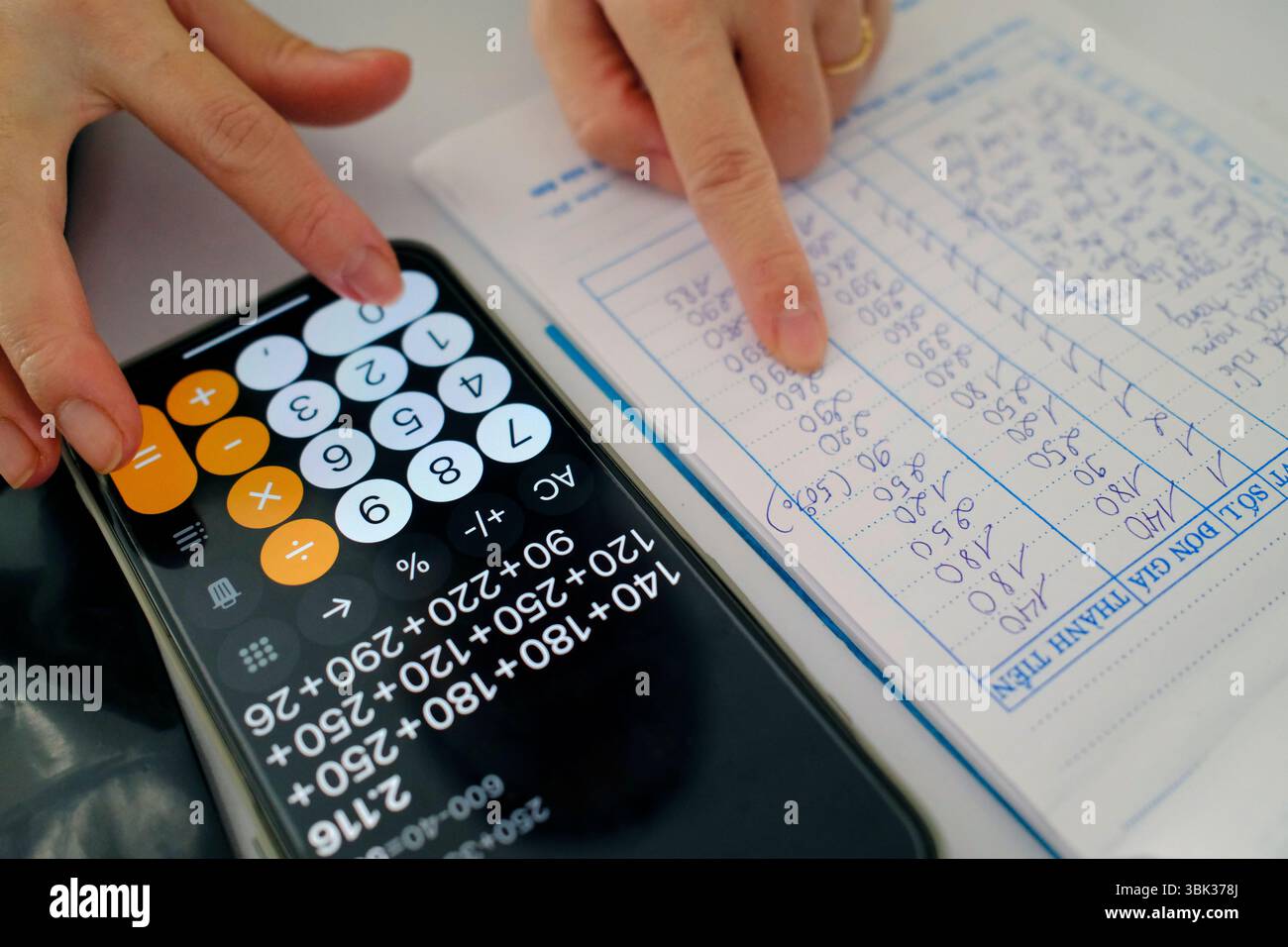 Femme utilisant une calculatrice dans un magasin. Comptabilité. Gros plan sur les mains. Kontum. Vietnam. Banque D'Images