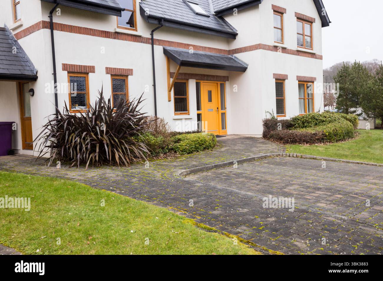 Illustration plate montrant une maison de deux étages dans la cour avec double porte orange, allée, haies, arbustes Banque D'Images