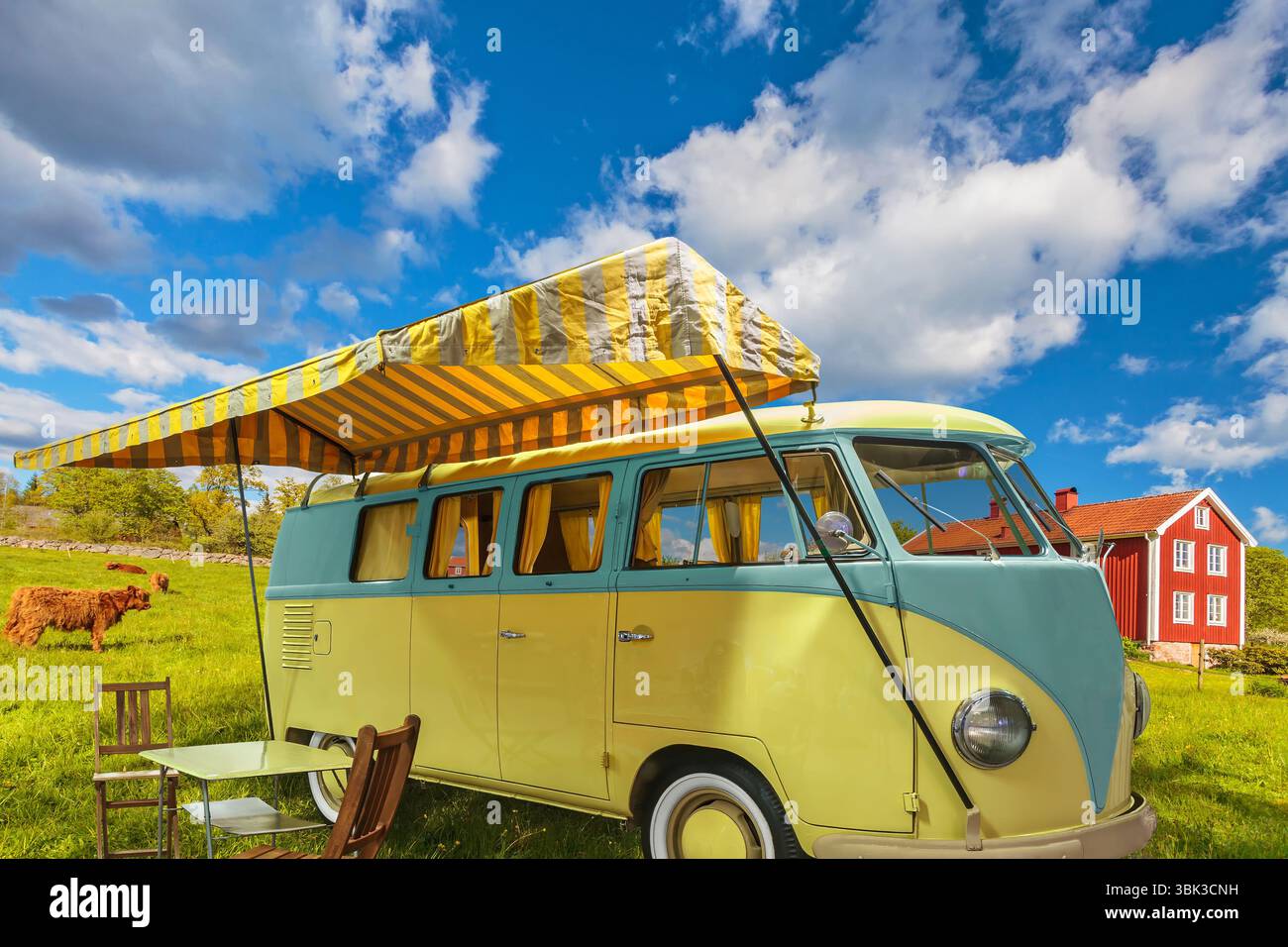 Camping-car vintage avec écran solaire dans un paysage suédois typique avec des vaches et un bâtiment de ferme rouge Banque D'Images