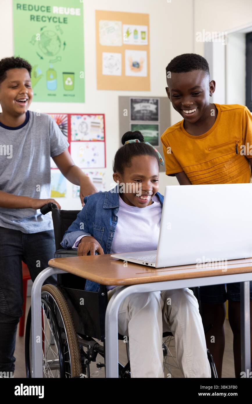 Divers étudiants divers en classe appréciant le contenu éducatif sur ordinateur portable ensemble, à l'école Banque D'Images