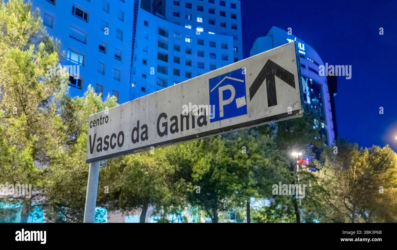 Lisbonne, Portugal - 21 mai 2025 : le panneau de rue la nuit pointe vers Centro Vasco da Gama, face à un ciel bleu profond et à une architecture urbaine moderne Banque D'Images