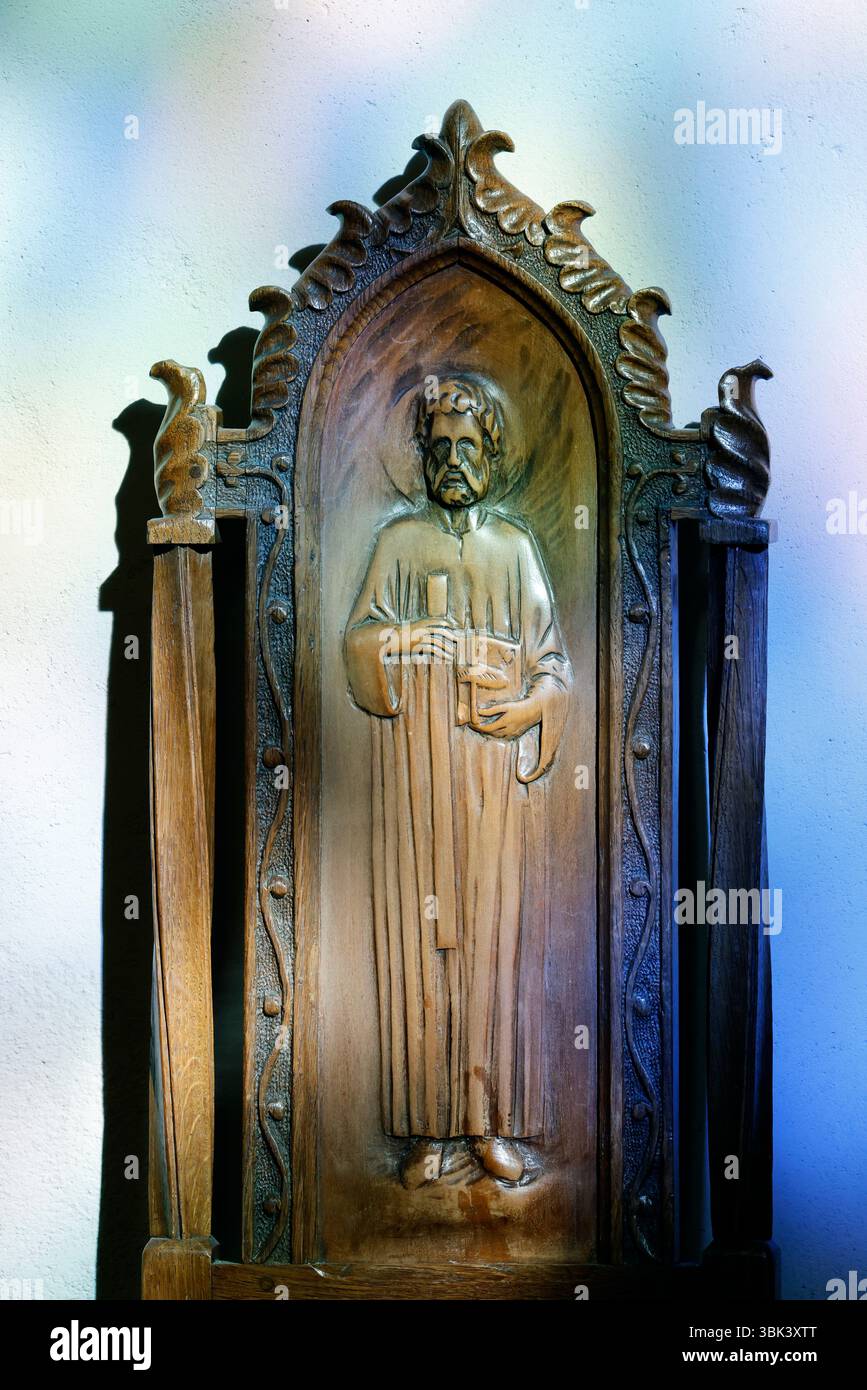 Église Saint Jean Baptiste. Assise en bois avec un dossier sculpté représentant un caractère biblique. Megève.France. Banque D'Images