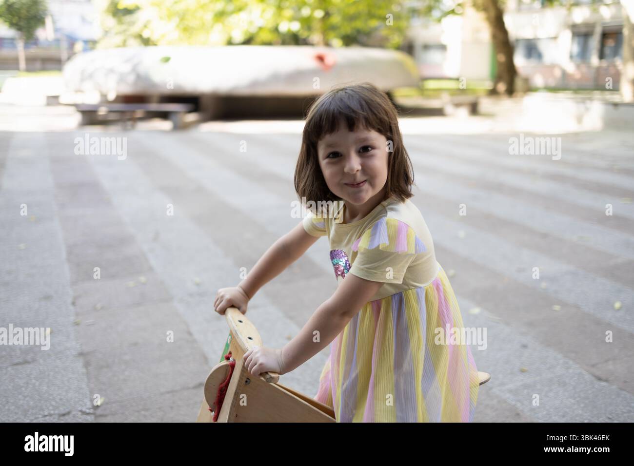 Un gamin jouant dehors sur son vélo d'équilibre. Banque D'Images